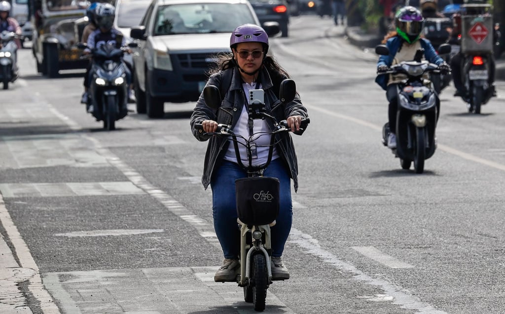 A person rides an electric scooter in Makati city in Metro Manila, Philippines. Photo: EPA-EFE A person rides an electric scooter in Makati city in Metro Manila, Philippines. Photo: EPA-EFE