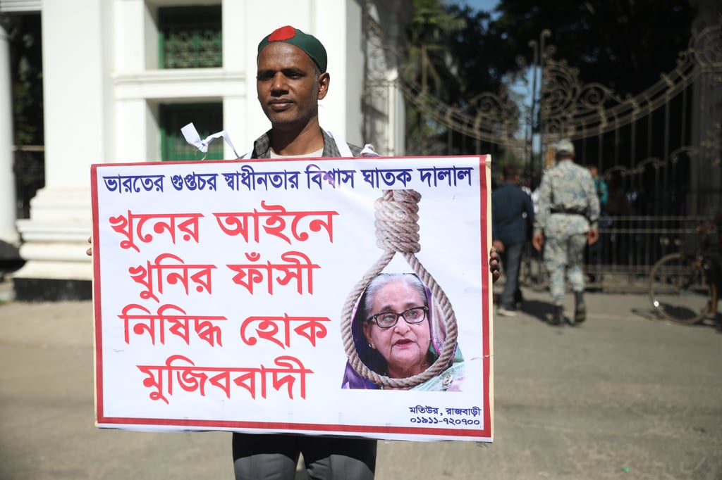A protester holds a placard featuring the face of former Bangladeshi prime minister Sheikh Hasina in the high court area in Dhaka on Monday. Photo: EPA A protester holds a placard featuring the face of former Bangladeshi prime minister Sheikh Hasina in the high court area in Dhaka on Monday. Photo: EPA