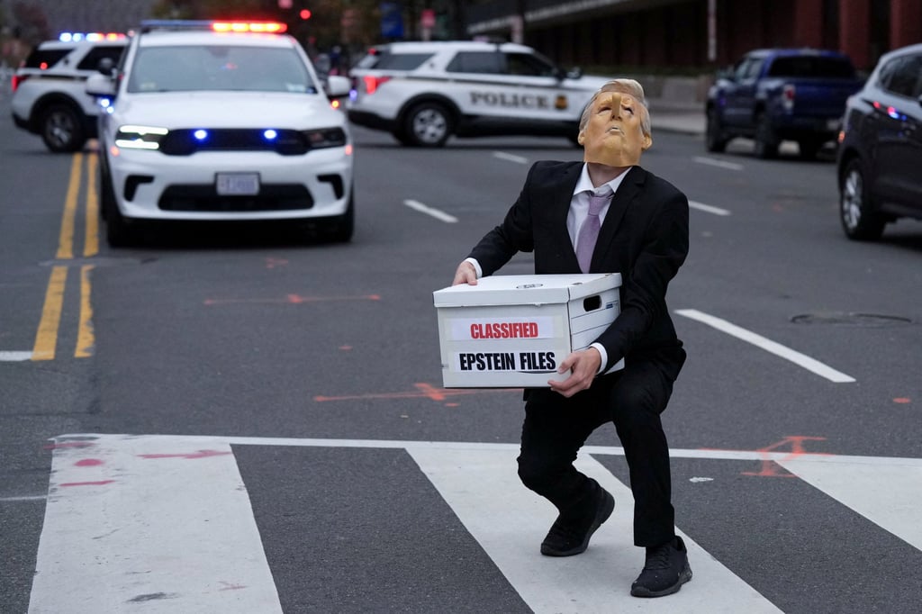 A demonstrator wearing a mask depicting US President Donald Trump carries a box outside the White House in Washington. Photo: Reuters
