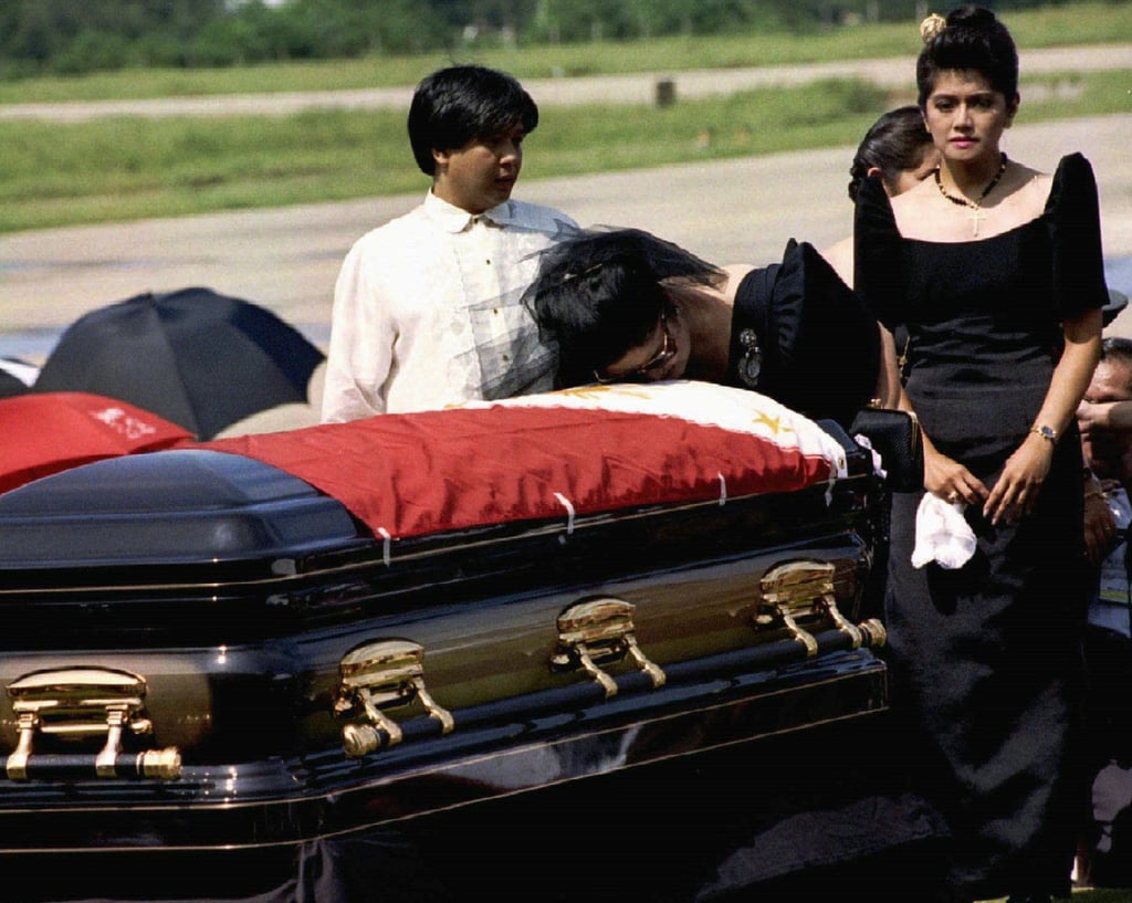 Imee (right) and Marcos Jnr (left) accompany their mother Imelda Marcos as she kisses the coffin containing the remains of her husband, Ferdinand Marcos Snr, after his body was repatriated to the Philippines from Hawaii in 1993. Photo: Reuters Imee (right) and Marcos Jnr (left) accompany their mother Imelda Marcos as she kisses the coffin containing the remains of her husband, Ferdinand Marcos Snr, after his body was repatriated to the Philippines from Hawaii in 1993. Photo: Reuters