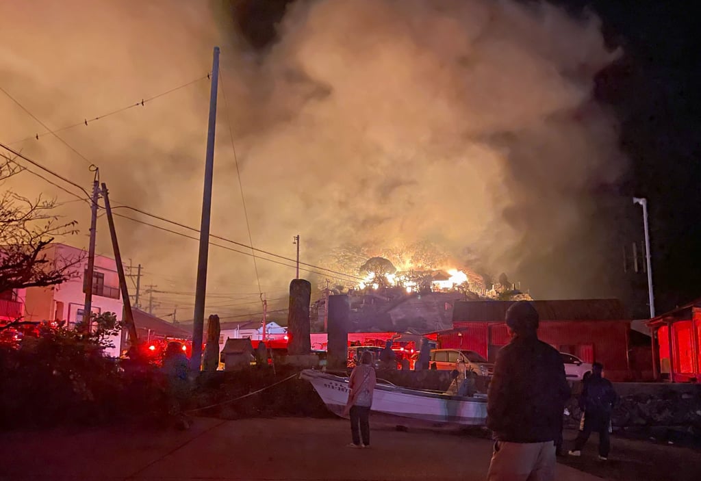 People watch smoke and flames rising from a massive fire in a dense residential area in the southwestern Japan city of Oita on Wednesday. Photo: Kyodo