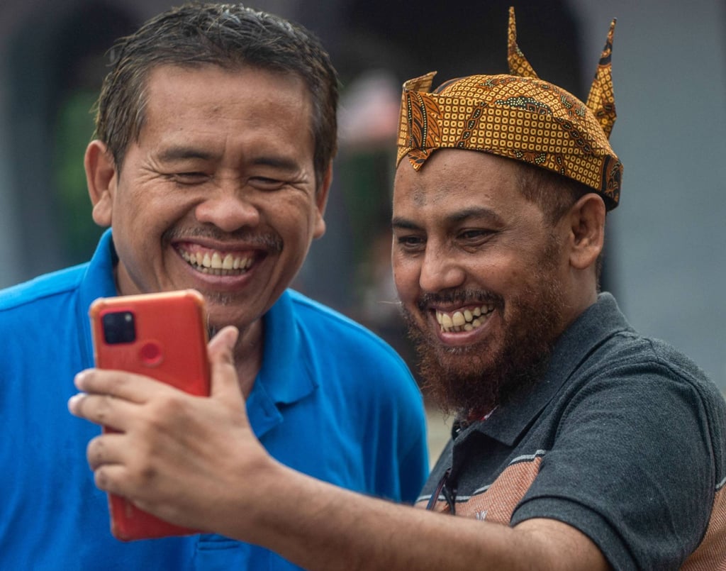 Umar Patek (right), one of the bombmakers in the Bali blasts, takes a selfie with Ali Fauzi, a brother of three of the bombers, after his early release from prison in December 2022. Photo: AFP