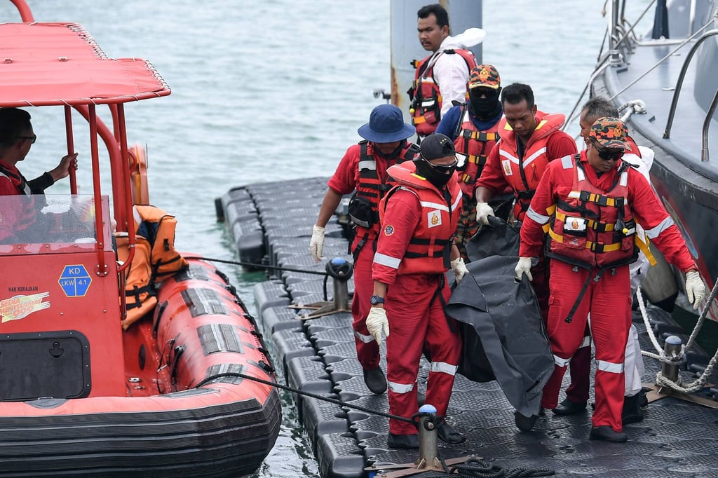 Malaysia rescuers carry a bag containing the body of a victim, days after a boat carrying migrants from Myanmar capsized. Photo: AFP