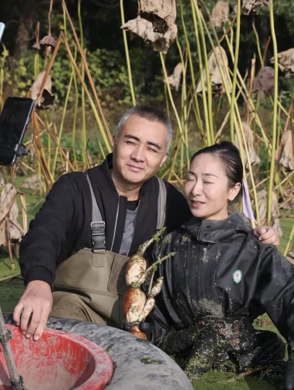 Hu photographed at work with her husband, who developed severe back pain from working in the lotus ponds. Photo: Baidu Hu photographed at work with her husband, who developed severe back pain from working in the lotus ponds. Photo: Baidu