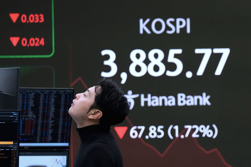 A currency trader reacts near a screen showing the Korea Composite Stock Price Index (Kospi) at the foreign exchange dealing room of the Hana Bank headquarters in Seoul on November 19. Photo: AP