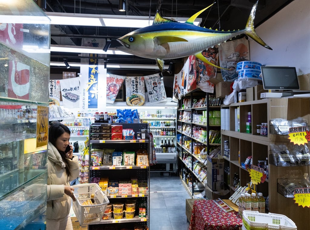A customer carries a basket in a store selling Japanese food products in Beijing on November 19, 2025. Photo: EPA