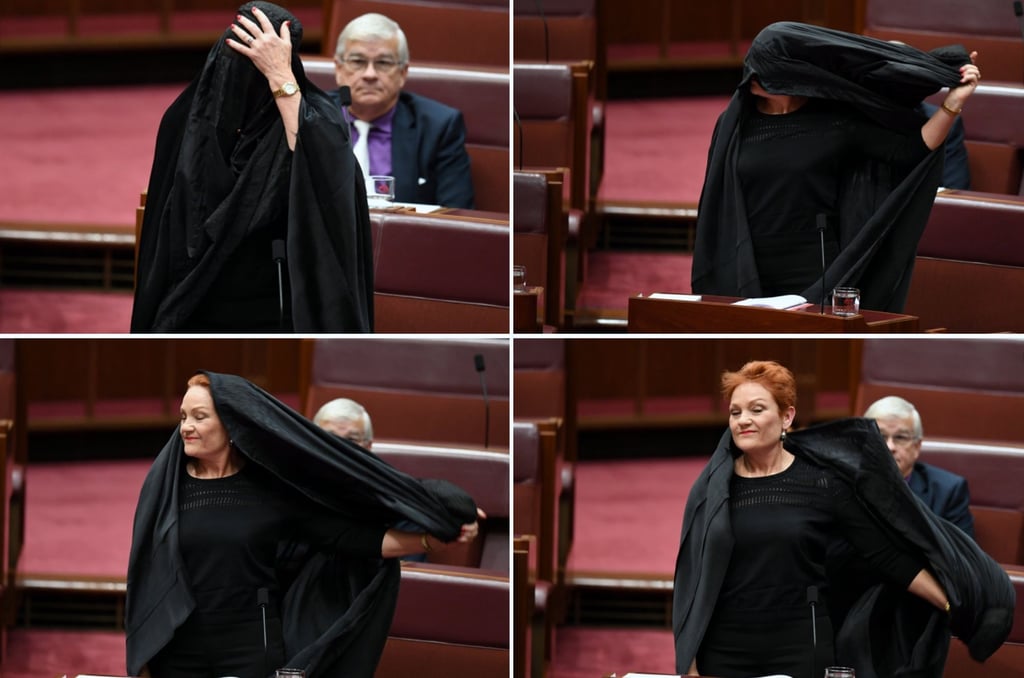 Pauline Hanson takes off a burka during Senate Question Time at Parliament House in Canberra on August 17, 2017. Photo: EPA