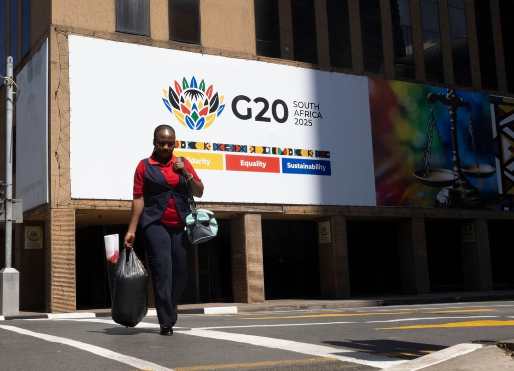A woman walks past a G20 Summit billboard in Johannesburg, South Africa, on November 13. Photo: EPA