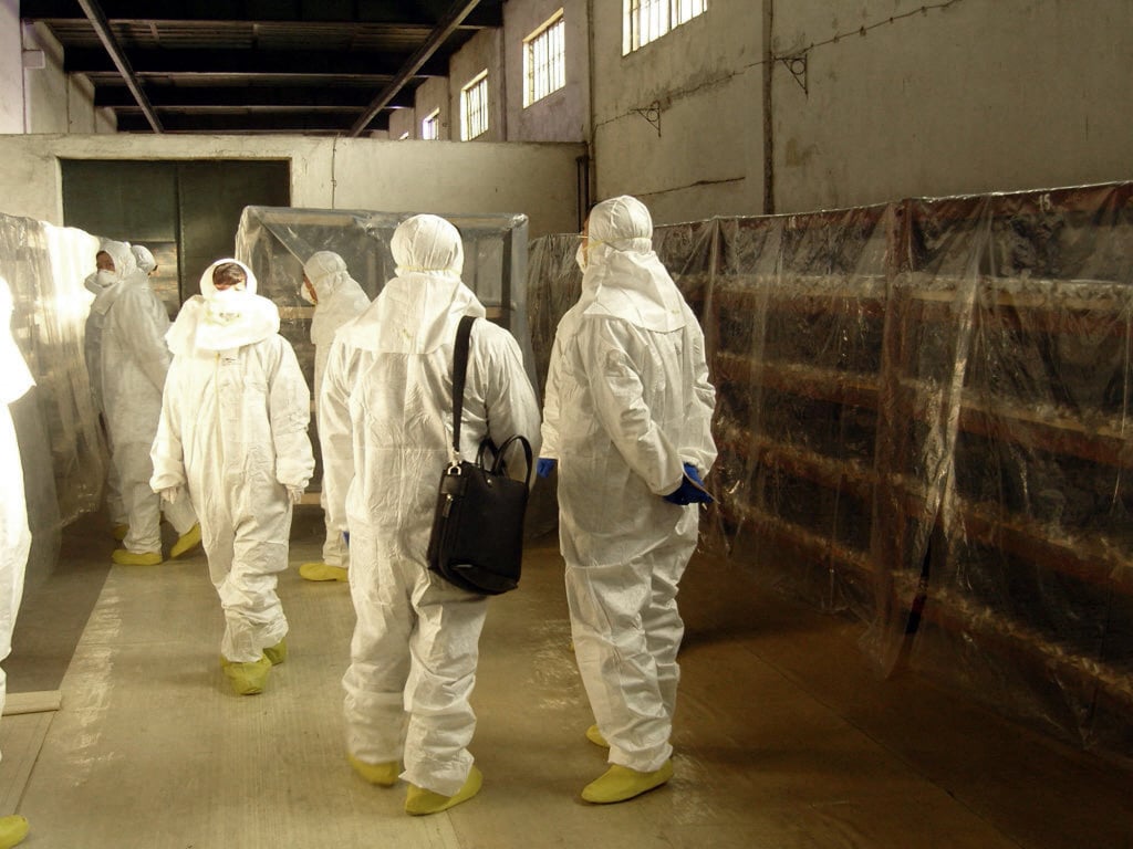 South Korean officials, dressed in radiation suits, inspect unused fuel rods stacked in a warehouse during a visit to the Yongbyon facility in 2009. Photo: South Korean Foreign Ministry/AFP