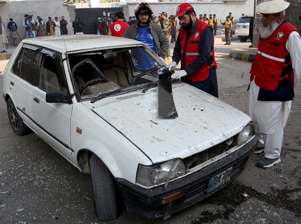 Rescuers inspect a damaged vehicle after suicide bombers targeted the headquarters of a Pakistani paramilitary force on Monday. Photo: Reuters Rescuers inspect a damaged vehicle after suicide bombers targeted the headquarters of a Pakistani paramilitary force on Monday. Photo: Reuters