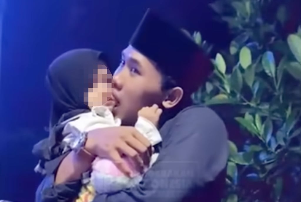 Islamic cleric Mohammad Elham Yahya Al Maliki is seen embracing a young girl and sucking in her cheeks. Other clips show him kissing several children on the cheek. Photo: YouTube/Gerakanpis