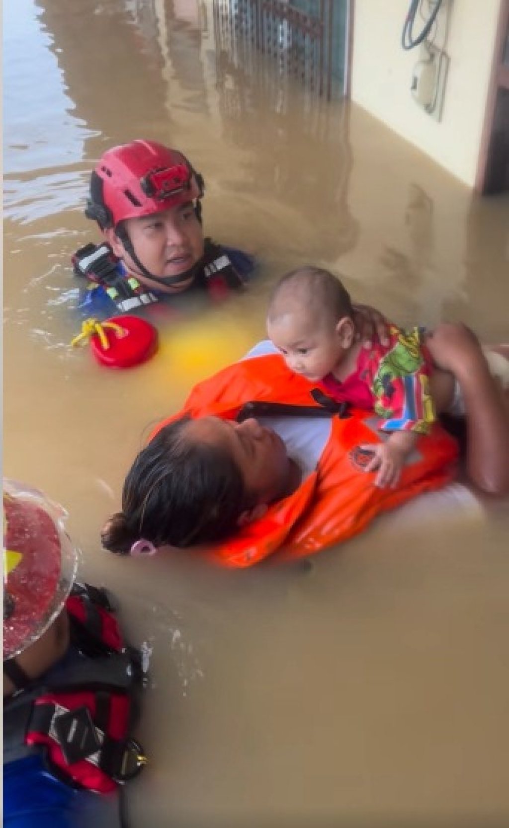 A baby rests on the chest of a woman in a life jacket as she is guided out from a flooded building in Hat Yai, Thailand. Photo: Facebook/เอกวัฒน์ ไชยจันลา เก่ง มหาศิลา A baby rests on the chest of a woman in a life jacket as she is guided out from a flooded building in Hat Yai, Thailand. Photo: Facebook/เอกวัฒน์ ไชยจันลา เก่ง มหาศิลา