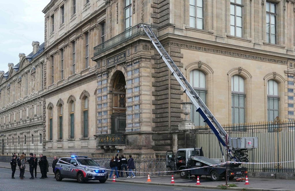French police officers stand next to a furniture lift used by robbers to enter the Louvre Museum on October 19. Photo: AFP