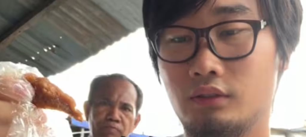 An intrepid influencer from China stares intently at a piece of the recooked chicken. Photo: Douyin. An intrepid influencer from China stares intently at a piece of the recooked chicken. Photo: Douyin.