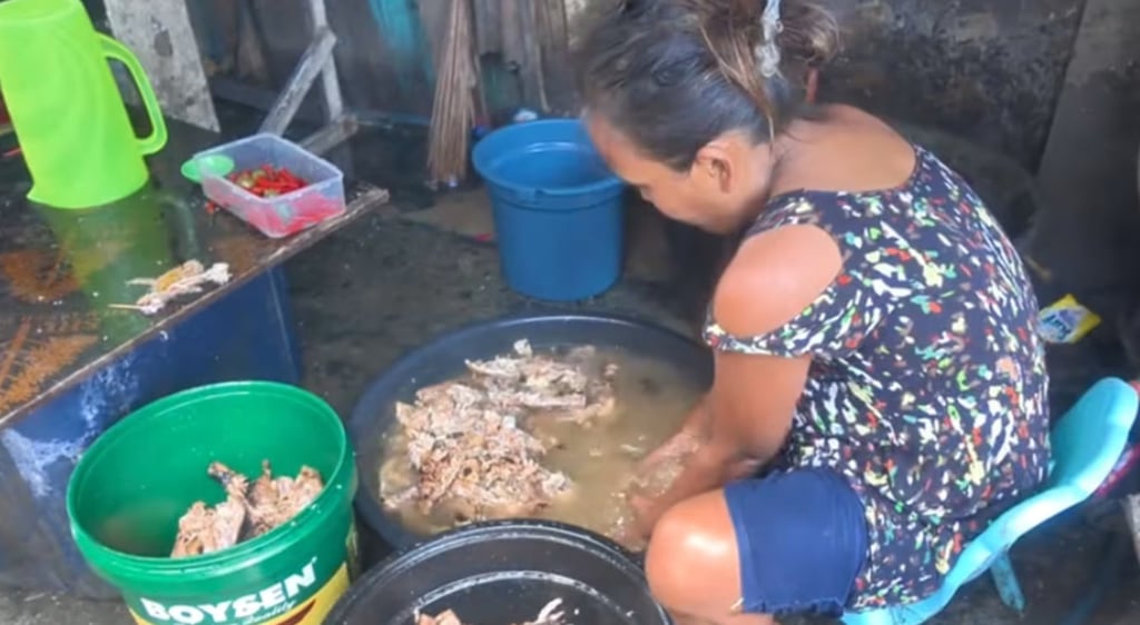 A Filipino woman washes the discarded meat in a basin before selling the leftovers to vendors. Photo: Douyin. A Filipino woman washes the discarded meat in a basin before selling the leftovers to vendors. Photo: Douyin.