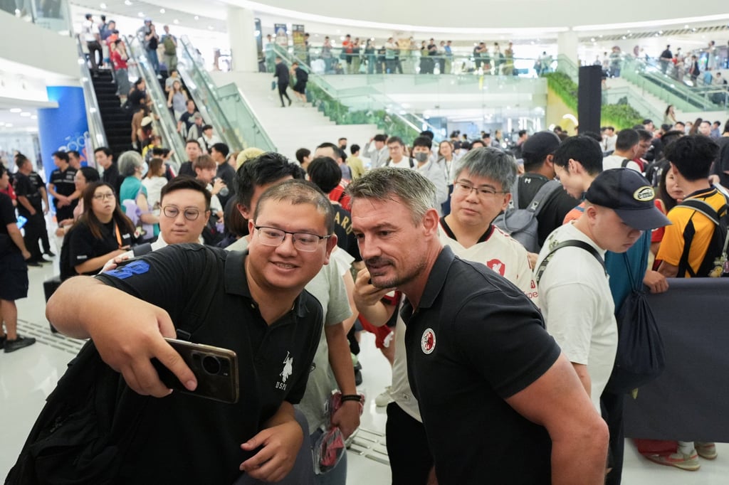 A fan takes a photo with Ashley Westwood (right), but plenty wanted him out of the picture. Photo: Eugene Lee