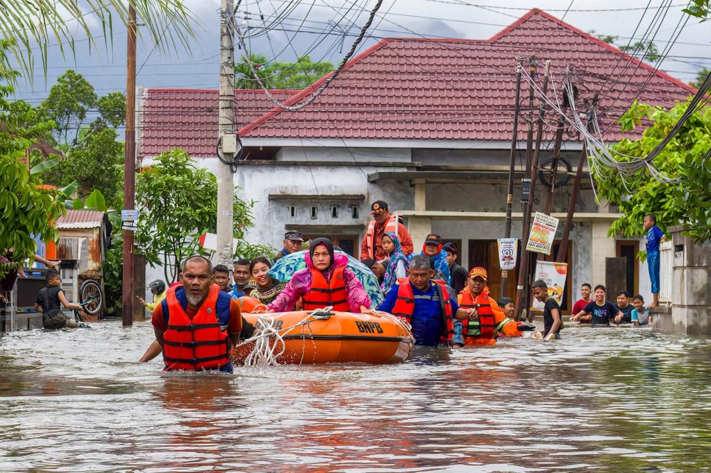 A rescue team evacuates women and children in a rubber boat as Tuesday. Photo: AFP A rescue team evacuates women and children in a rubber boat as Tuesday. Photo: AFP