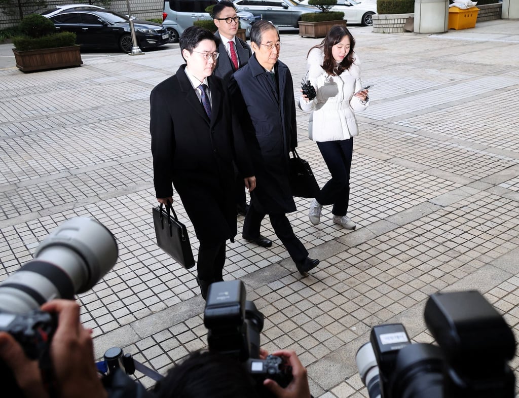 Former prime minister Han Duck-soo (centre) arrives for the closing hearing of his case at the Seoul Central District Court on Wednesday. Photo: Reuters Former prime minister Han Duck-soo (centre) arrives for the closing hearing of his case at the Seoul Central District Court on Wednesday. Photo: Reuters