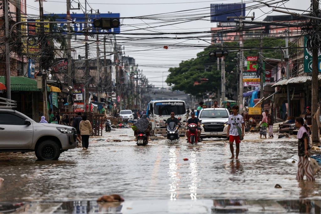People commute through a flooded area in Hat Yai district on Friday. Photo: Reuters