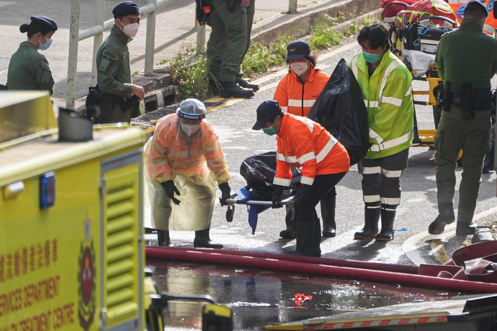 Workers transport a deceased victim away in the morning. Photo: Eugene Lee Workers transport a deceased victim away in the morning. Photo: Eugene Lee