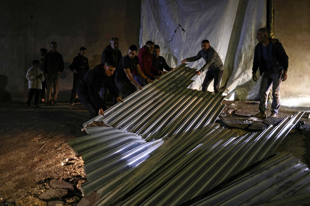 People help clean the site of the shooting that left two Palestinians dead. Photo: AFP People help clean the site of the shooting that left two Palestinians dead. Photo: AFP