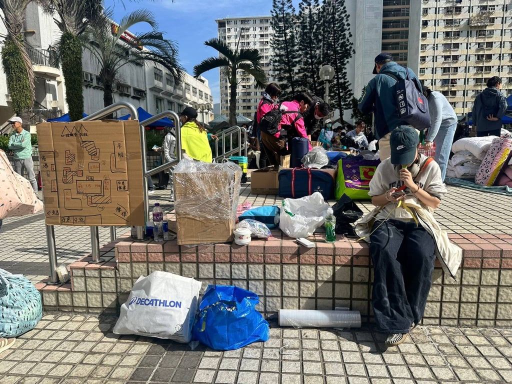 Volunteer Jay (in a blue cap) sits next to a cardboard map of the area. Photo: Natalie Wong Volunteer Jay (in a blue cap) sits next to a cardboard map of the area. Photo: Natalie Wong