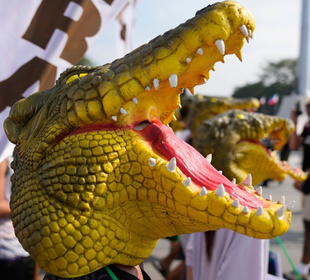 Protesters wearing crocodile masks take part in an anti-corruption protest in Manila on Sunday. Photo: AP Protesters wearing crocodile masks take part in an anti-corruption protest in Manila on Sunday. Photo: AP