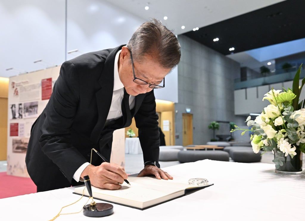 Financial Secretary Paul Chan signs a condolence book for the victims of the fire at the Central Government Offices in Tamar. Photo: ISD