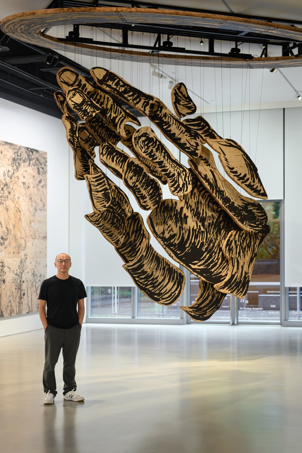 Lam Tung-pang stands beside his work Praying Hands (2025) at his solo exhibition “Everyone’s Journey Toward Faith is Different”, at Galerie du Monde’s Taipei space. Photo: Anpis Wang