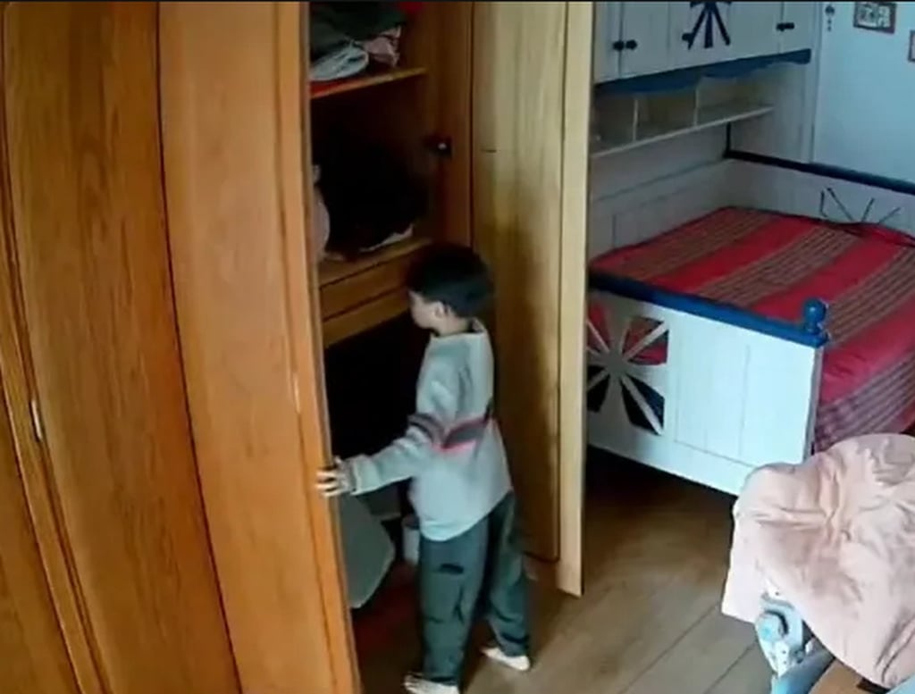 Household video footage shows the youngster looking in a cupboard. Photo: QQ.com Household video footage shows the youngster looking in a cupboard. Photo: QQ.com