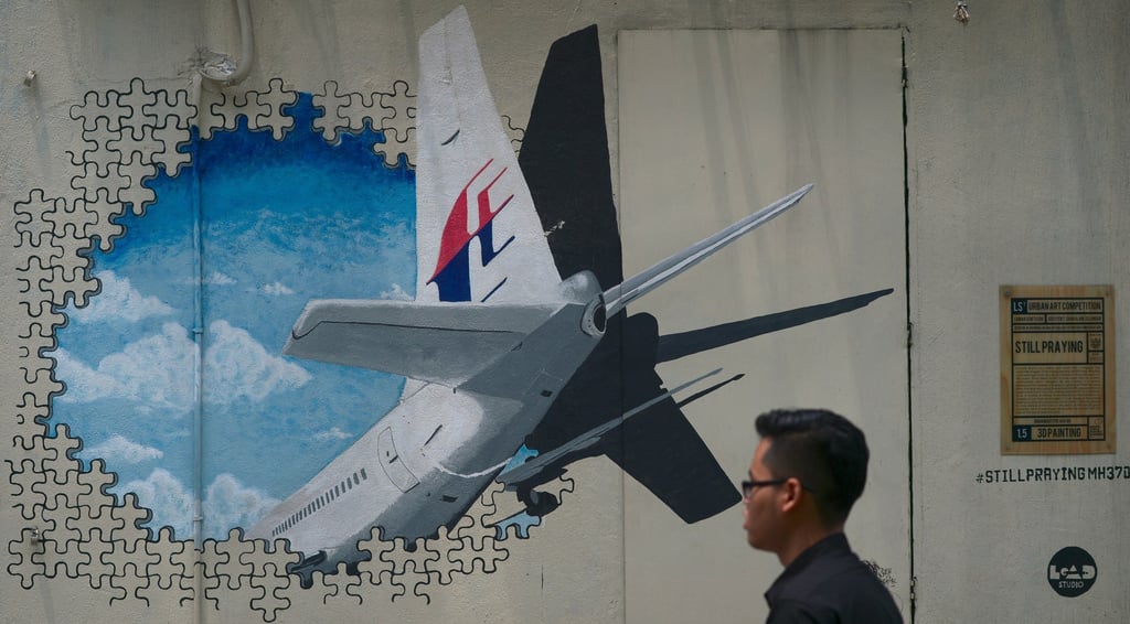 A man walks past a mural representing the missing flight MH370 on August 26, 2015. Photo: AFP