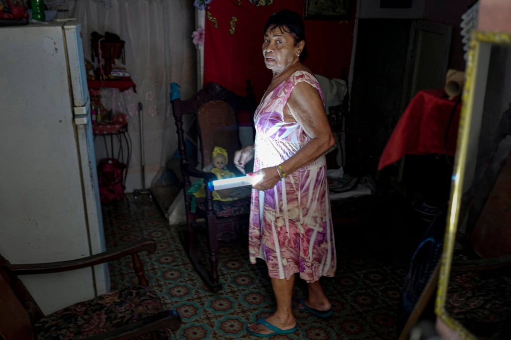 A Havana resident lights her house with a lamp during a power outage on November 20. Photo: AFP