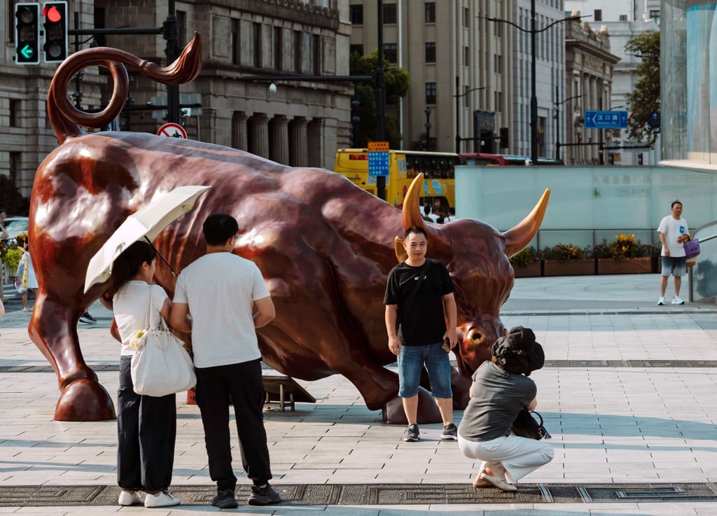 Tourists take photos in front of the bull statue in Shanghai, August 7, 2025. Photo: EPA Tourists take photos in front of the bull statue in Shanghai, August 7, 2025. Photo: EPA