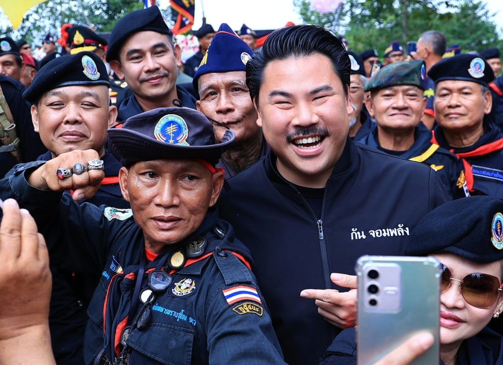 Self-styled social media influencer Gun Jompalang with Thai officers. Photo: Handout Self-styled social media influencer Gun Jompalang with Thai officers. Photo: Handout
