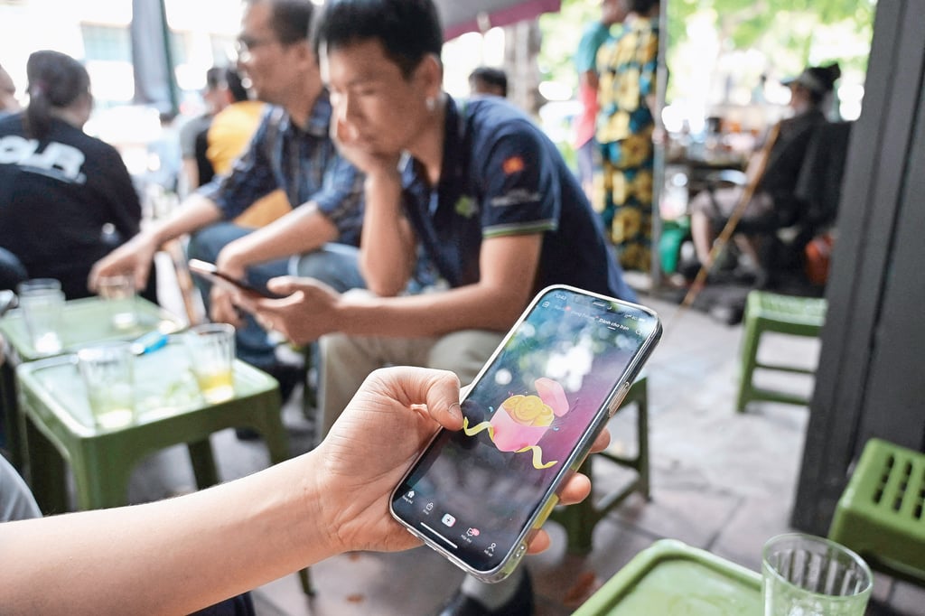 People check social media on their smartphones in Hanoi, Vietnam, in 2023. Photo: AFP