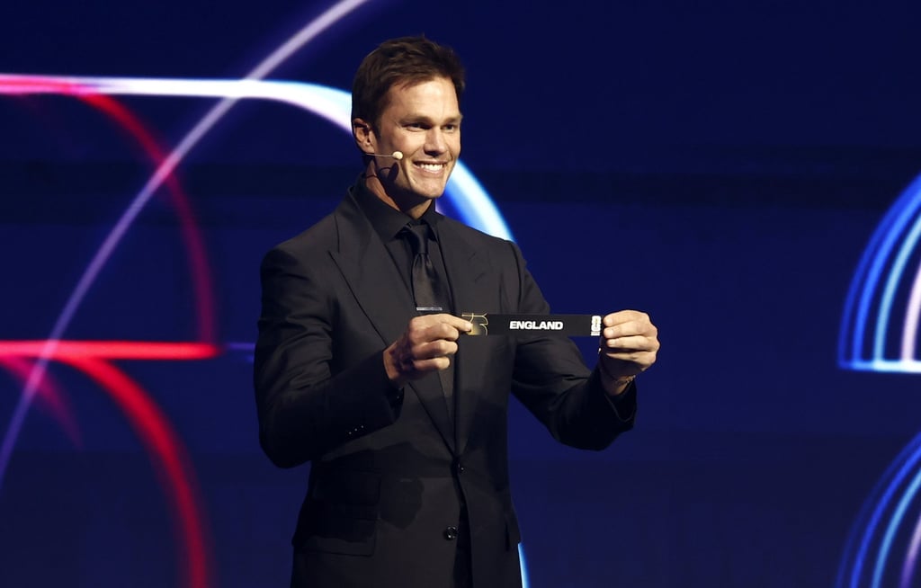Draw assistant Tom Brady holds the ticket of England as the groups take shape in Washington. Photo: EPA