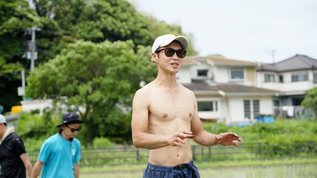 Sho Nakano teaches volunteers the basics of weeding a field by hand. Photo: SCMP Sho Nakano teaches volunteers the basics of weeding a field by hand. Photo: SCMP