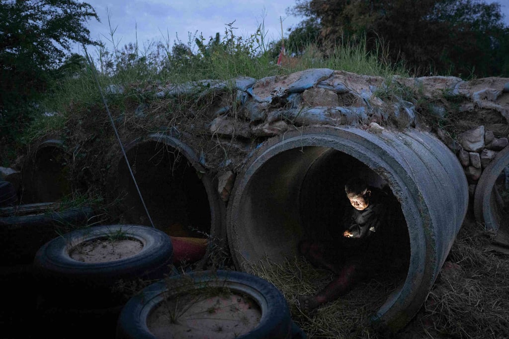 A Thai resident who fled clashes between Thai and Cambodian soldiers uses his mobile phone while taking shelter in Buriram province on Tuesday. Photo: AP A Thai resident who fled clashes between Thai and Cambodian soldiers uses his mobile phone while taking shelter in Buriram province on Tuesday. Photo: AP
