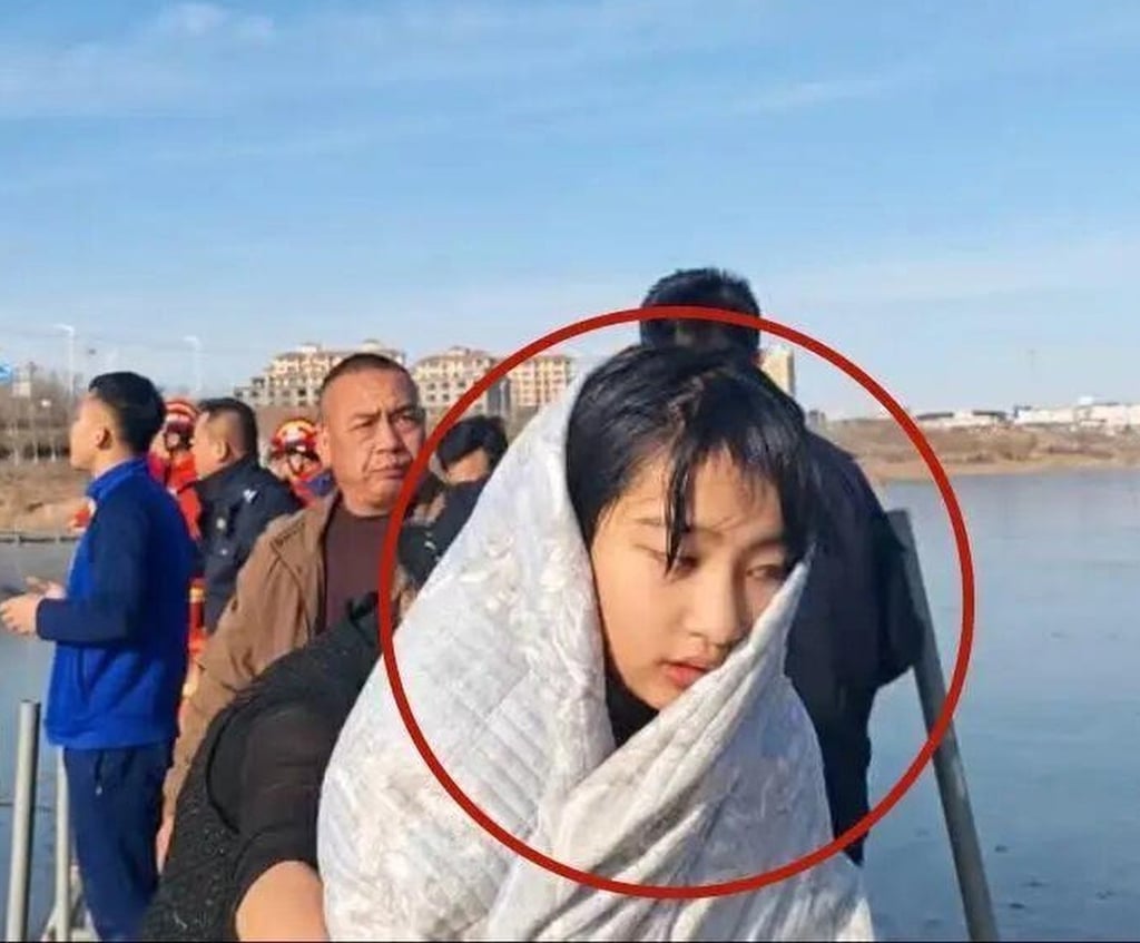 13-year-old Li Jiating wrapped in a blanket after she emerged from the freezing water. Photo: Baidu