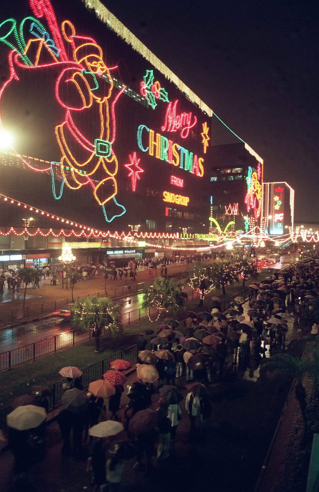 Despite the rain, crowds throng Tsim Sha Tsui East on Christmas Eve in 1994 to see the festive decorations. Photo: Dickson Lee Despite the rain, crowds throng Tsim Sha Tsui East on Christmas Eve in 1994 to see the festive decorations. Photo: Dickson Lee