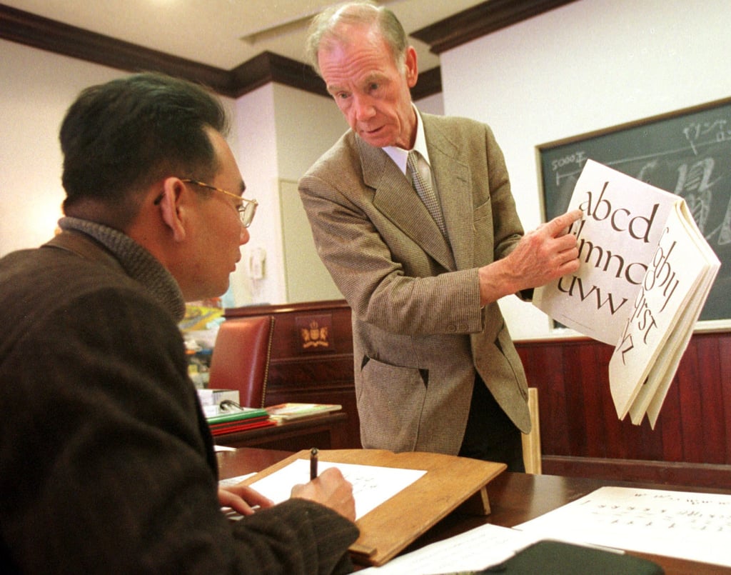 A British teacher shows a Japanese student how to write English calligraphy in 2000. Photo: AP A British teacher shows a Japanese student how to write English calligraphy in 2000. Photo: AP