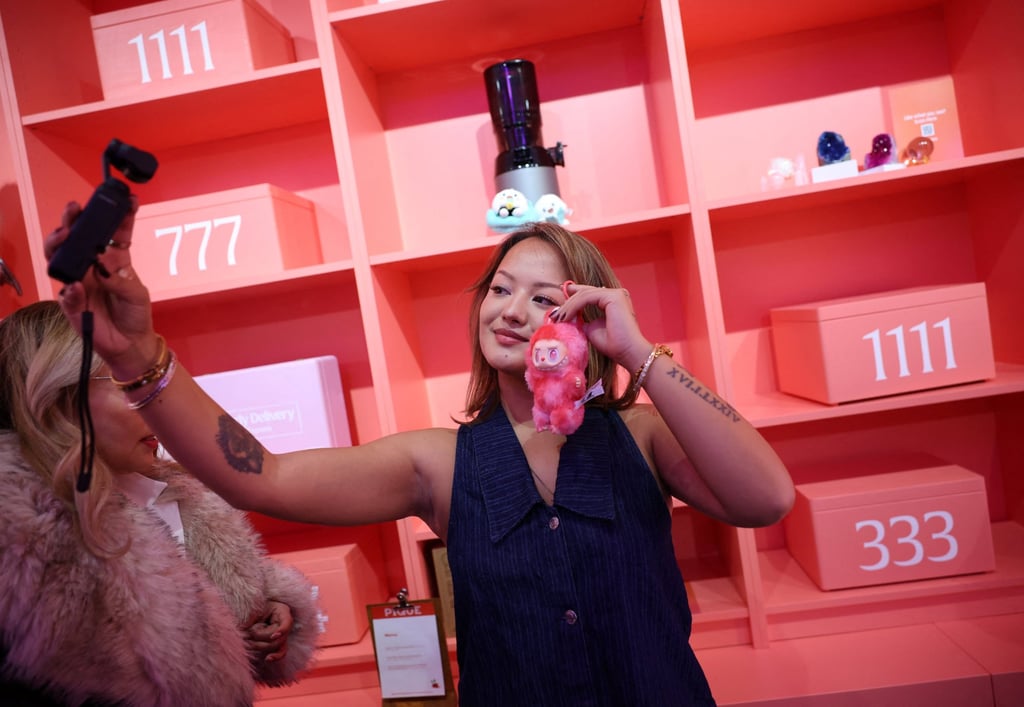 An influencer takes a selfie with a Labubu doll at a pop-up store in London in November 2025. Photo: Reuters