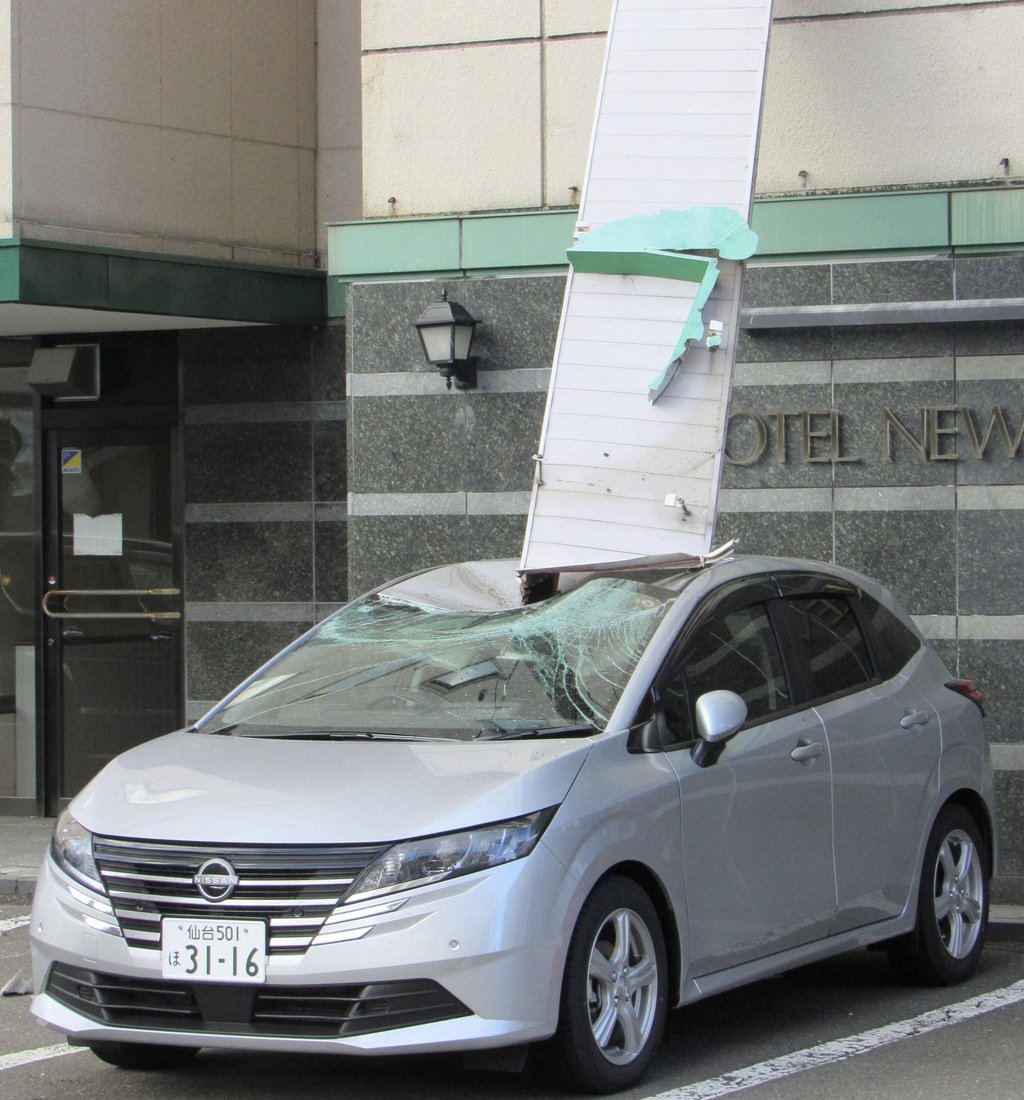 A car parked outside a hotel in Mutsu, Aomori prefecture, is damaged by a signboard that fell after a strong earthquake on Monday. Photo: Kyodo/Reuters A car parked outside a hotel in Mutsu, Aomori prefecture, is damaged by a signboard that fell after a strong earthquake on Monday. Photo: Kyodo/Reuters