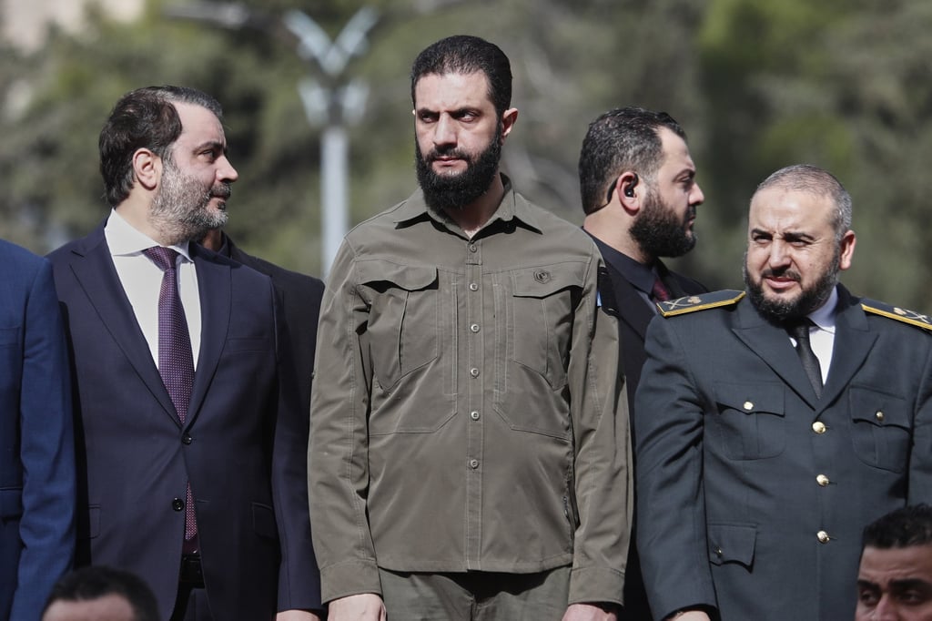 Syria’s interim President Ahmad al-Sharaa, centre, Defence Minister Murhaf Abu Qasra, right, and Foreign Minister Asaad al-Shibani, left, stand during celebrations in Damascus on December 8 marking the first anniversary of the ousting of former President Bashar Assad. Photo: AP