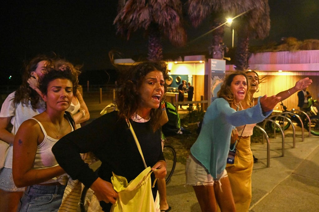 Youngsters react as they leave the site of an attack by gunmen at Bondi Beach on Sunday evening. Photo: AFP Youngsters react as they leave the site of an attack by gunmen at Bondi Beach on Sunday evening. Photo: AFP