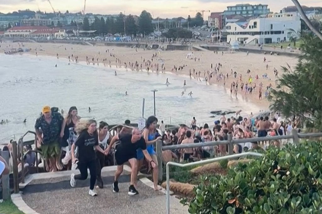 This screen grab, courtesy of Mike Ortiz, shows people fleeing Bondi Beach on Sunday after gunmen opened fire. Photo: Handout via AFP