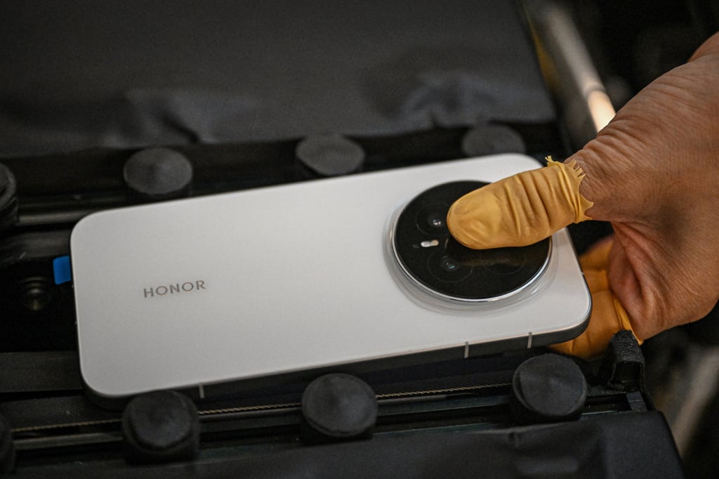 A worker on a production line holds an Honor Magic 8 smartphone at a factory in Shenzhen in October. Photo: AFP A worker on a production line holds an Honor Magic 8 smartphone at a factory in Shenzhen in October. Photo: AFP