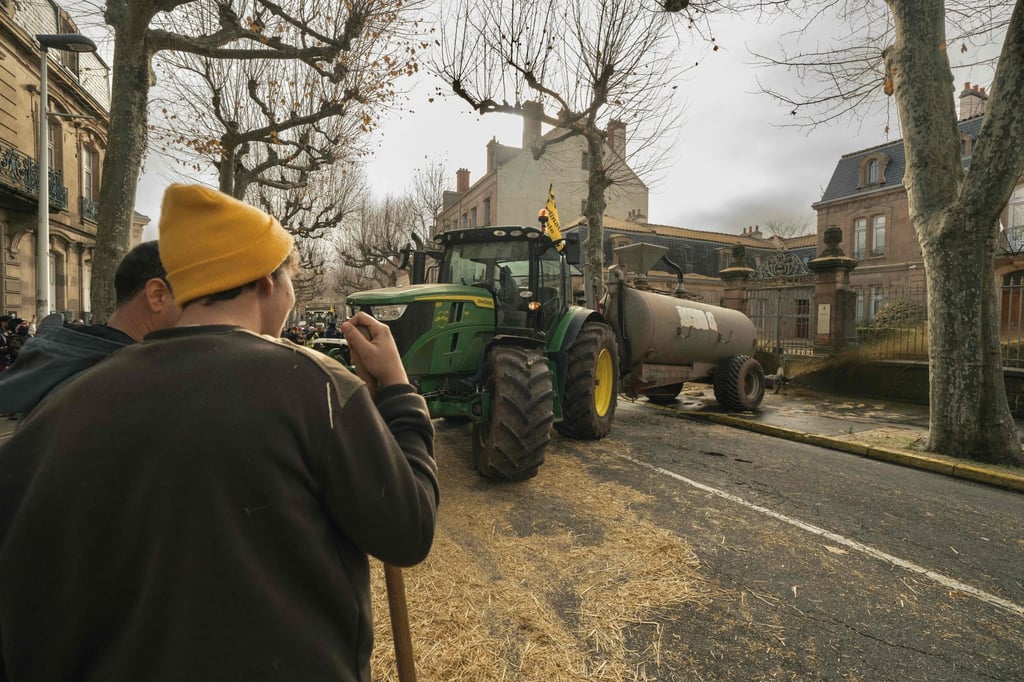 A tractor sprays liquid manure on the facade of government offices in Millau, central France. Photo: AFP A tractor sprays liquid manure on the facade of government offices in Millau, central France. Photo: AFP