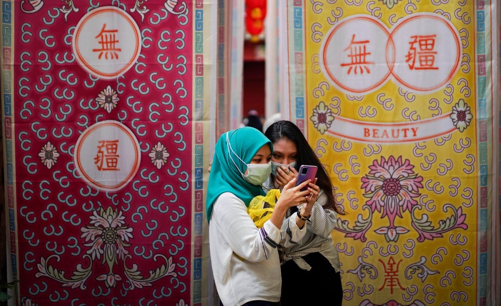 Malay girls check a mobile phone in Kuala Lumpur, Malaysia. Photo: AP Malay girls check a mobile phone in Kuala Lumpur, Malaysia. Photo: AP