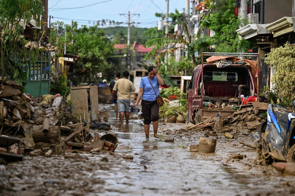 A woman walks along a mud-covered street in Liloan, Cebu province, in the aftermath of Typhoon Kalmaegi on November 6. Photo: AFP